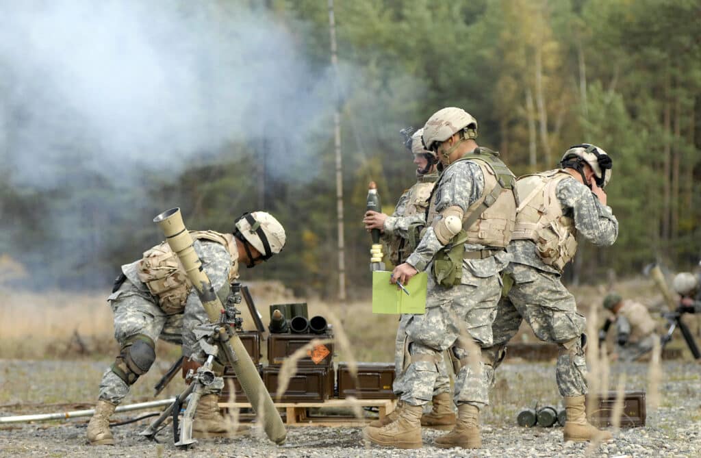 US soldiers firing explosive artillery shells.