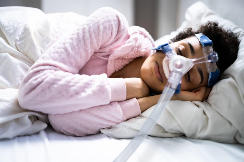 Woman sleeping on the side with a CPAP sleeping mask