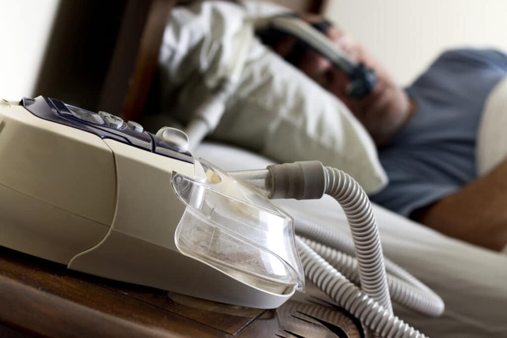 Man sleeping with a CPAP machine sleeping mask.