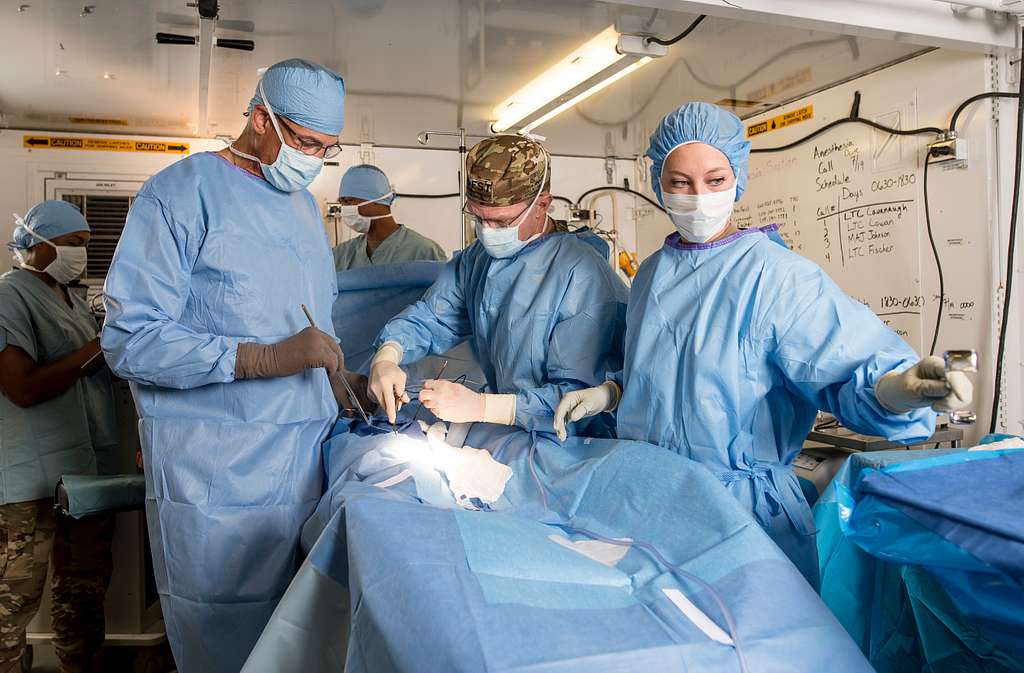 Surgeons performing hernia mesh revision surgery.